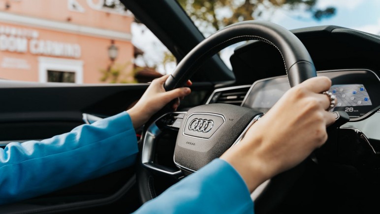 CLOSE UP OF  WOMAN HOLDING THE WHEEL IN A NEW AUDI CAR