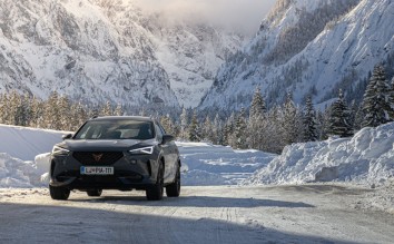 GRAY CUPRA FORMENTOE CAR ON SNOW COVERED ROAD