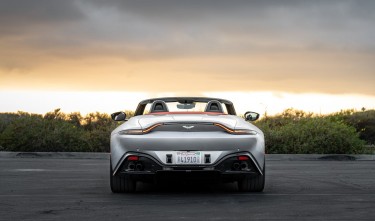 GRAY ASTON MARTIN ON THE ROAD DURING SUNSET