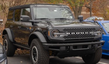 A BLACK VEHICLE PARKED FORD BRONCO