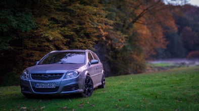AN OPEL VECTRA PARKED NEAR AUTUMNAL TREES IN A PARK