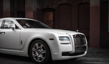 PHOTO OF WHITE ROLLS-ROYCE GHOST PARKED NEAR BROWN BUILDING