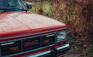 RED CLASSIC GMC JIMMY CAR COVERED WITH RAIN DROPS