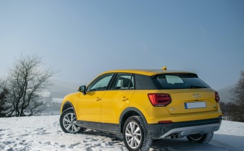 A YELLOW AUDI CAR PARKED ON A SNOW COVERED GROUND
